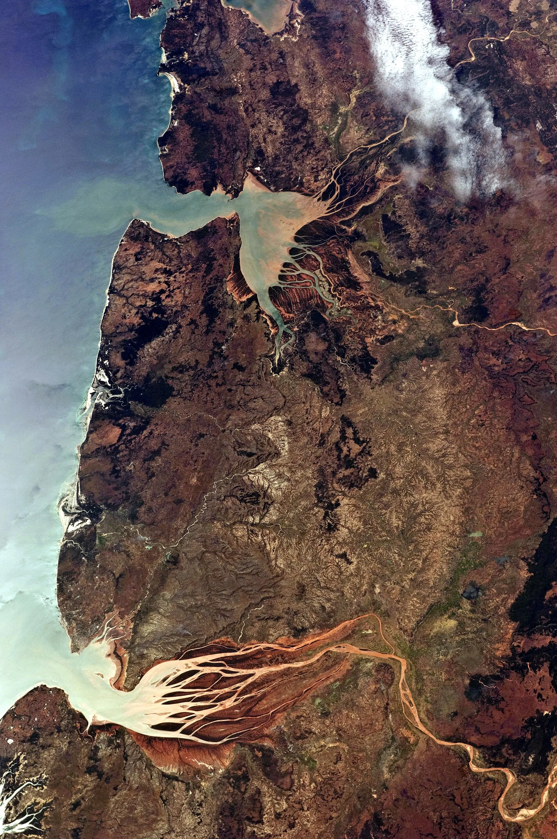 Photographie prise depuis l'orbite : deux estuaires de la côte nord-ouest de Madagascar, où des panaches de sédiment rouge s'étalent en éventail dans une mer turquoise.